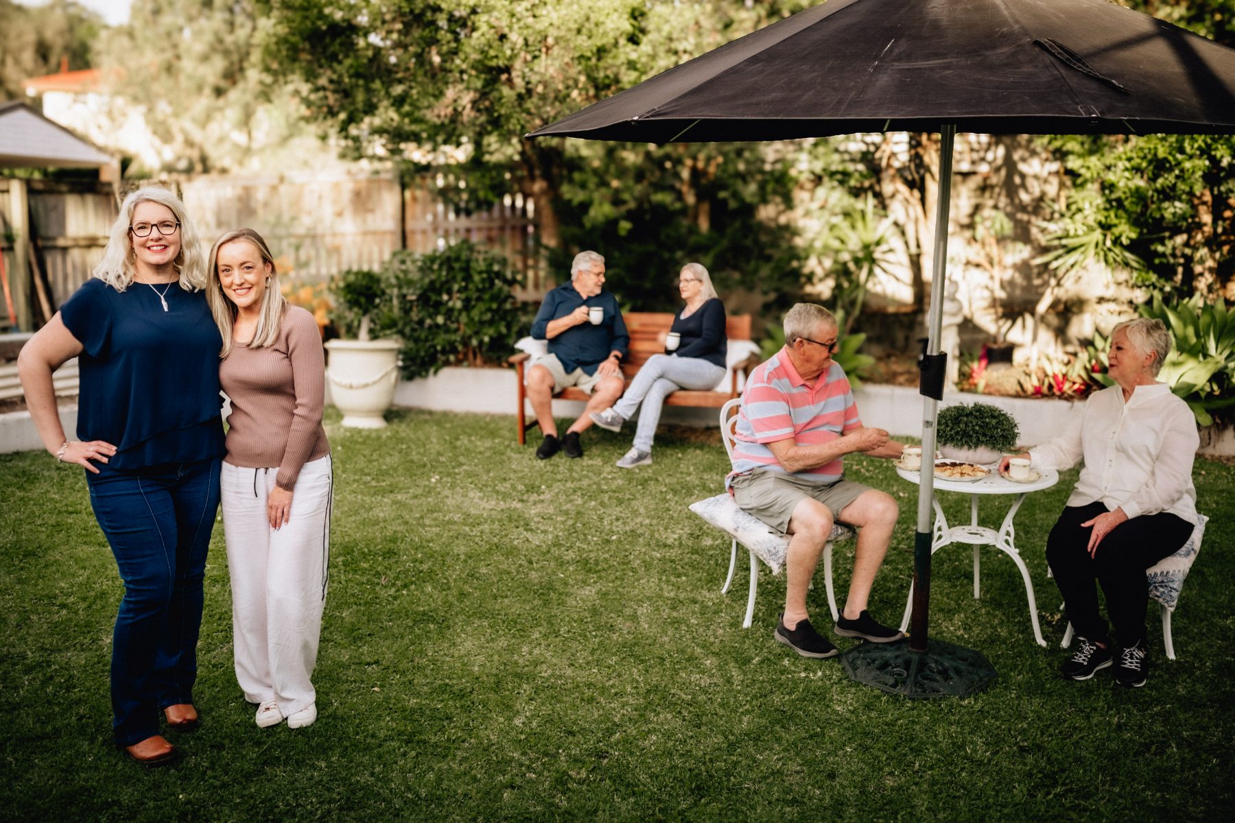 Clare and Candy with clients enjoying afternoon tea in a sunny Queensland garden