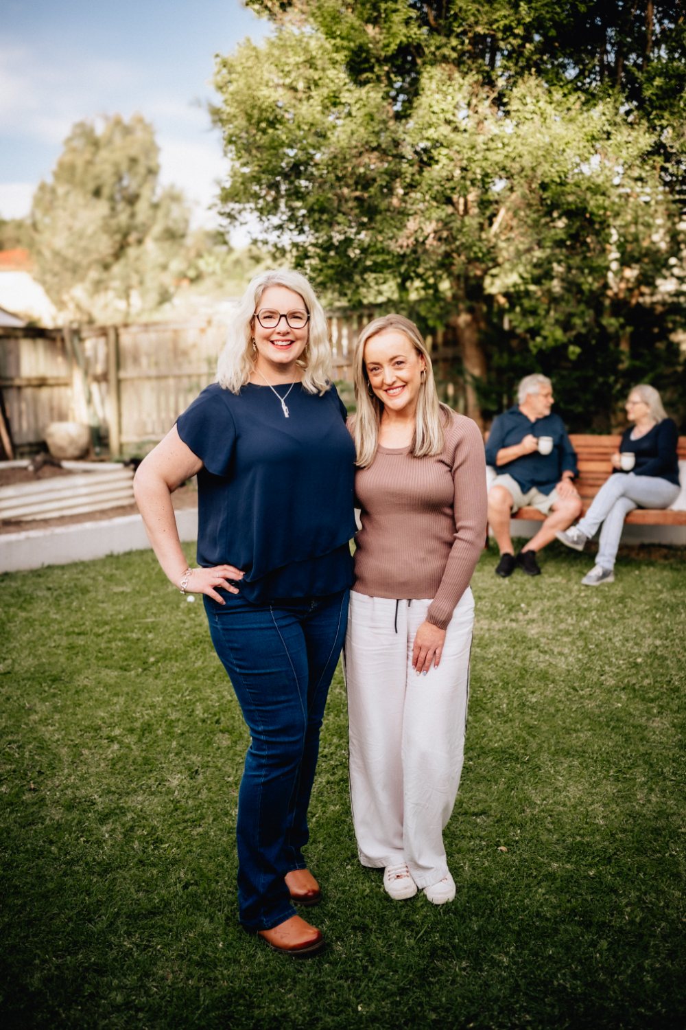 Clare and Candy, directors of Upside Downsize, in a garden with clients